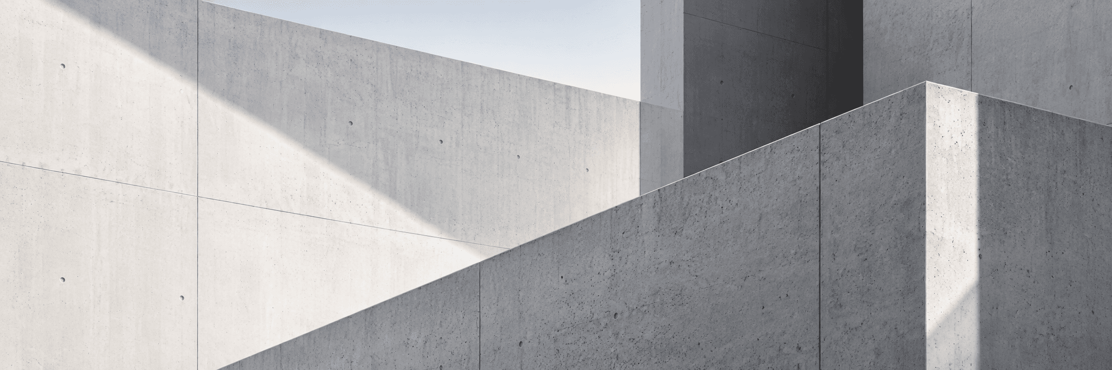 Architectural detail of a light concrete structure in daylight, clean structural geometry.